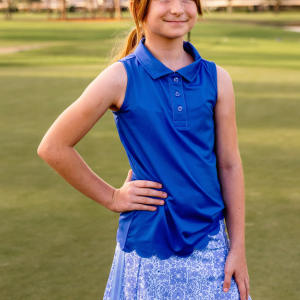 A young girl. stands on a golf course modeling a pink polo shirt