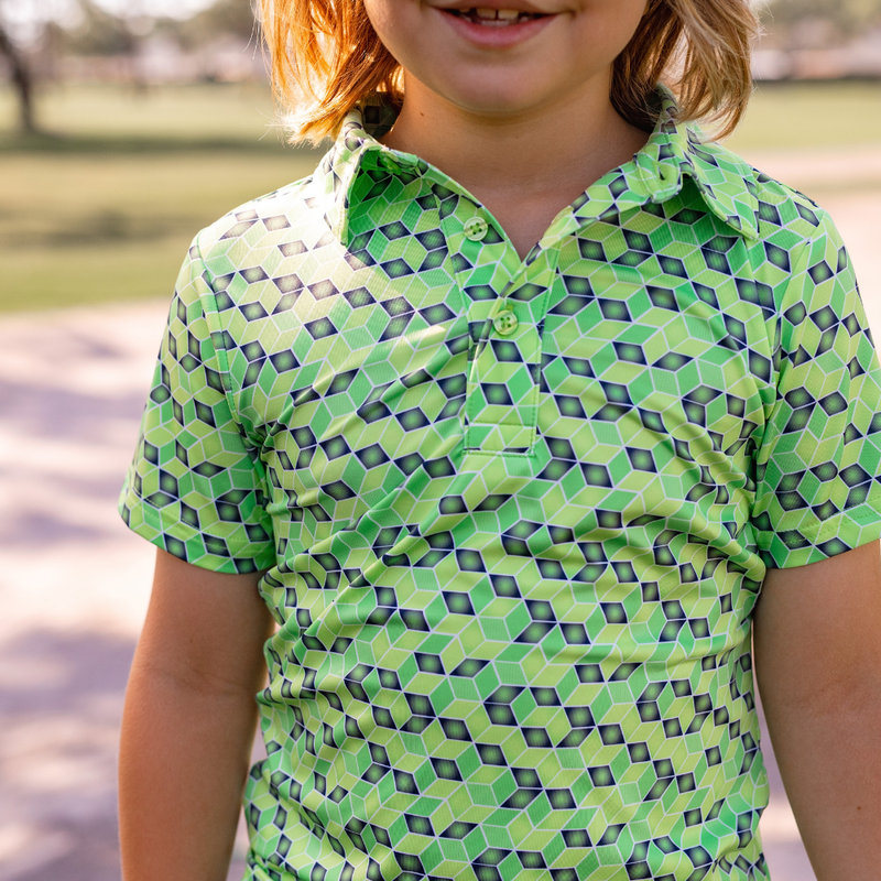Child wearing a Turtles and Tees green geometric patterned shirt outdoors