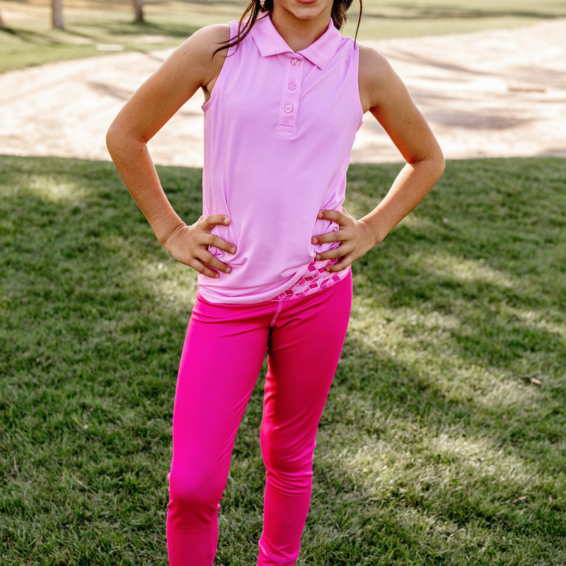Person wearing a Turtles and Tees pink sleeveless top and bright pink pants standing on grass.