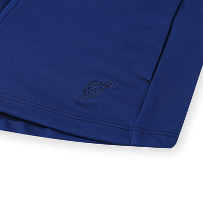 A turtle logo detail on the corner of a kids Turtles and Tees navy blue and green pullover.
