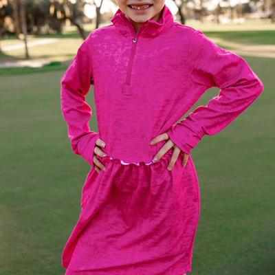 A young girl models a Turtles and Tees girls hot pink long sleeve golf dress