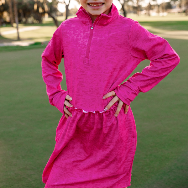 A young girl models a Turtles and Tees girls hot pink long sleeve golf dress