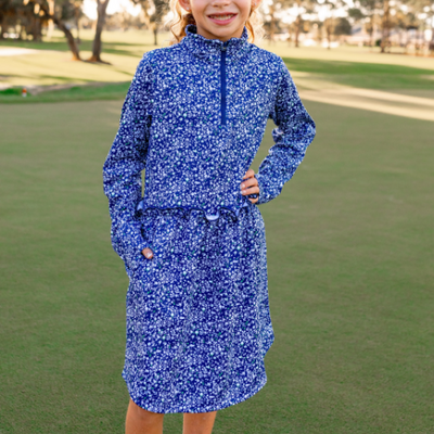 A young girl models a Turtles and Tees long sleeve floral blue golf dress