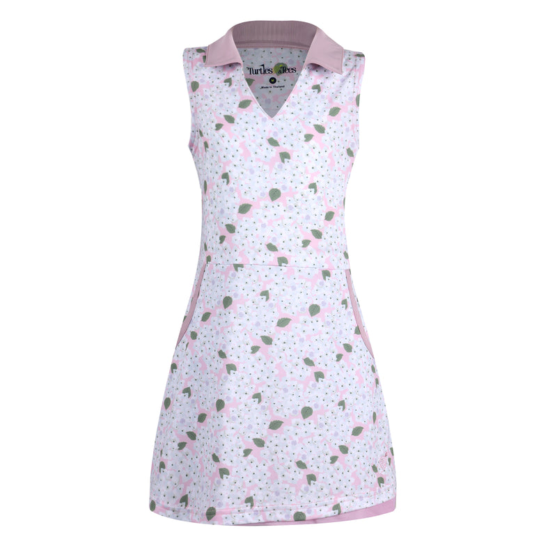 Girls golf dress or tennis dress in light pink, with white-blue flowers and green leaves printed on it.