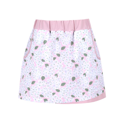 A girl's pink golf skort with white flowers and green vine leaves on it.